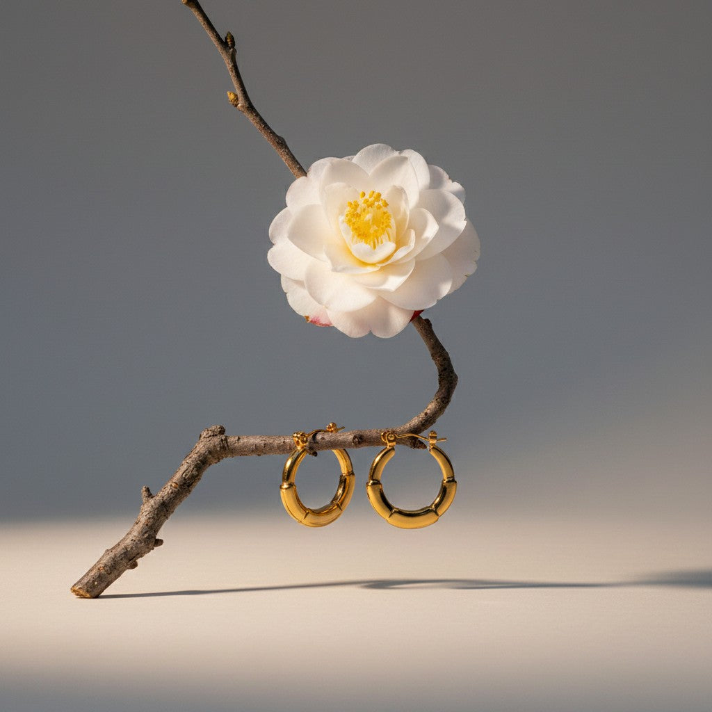 Aramat Jewels small gold-tone stainless steel hoop earrings with segmented design and hinge closure.