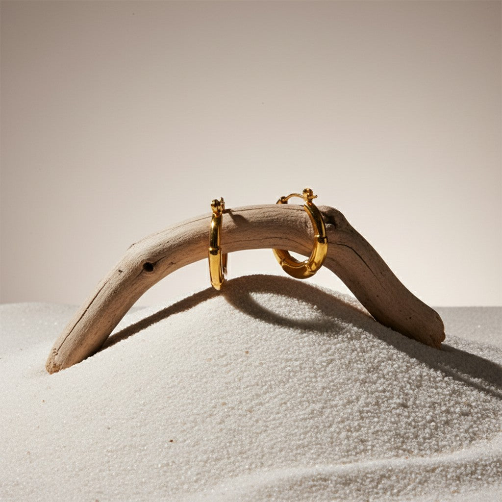 Aramat Jewels small gold-tone stainless steel hoop earrings with segmented design and hinge closure.
