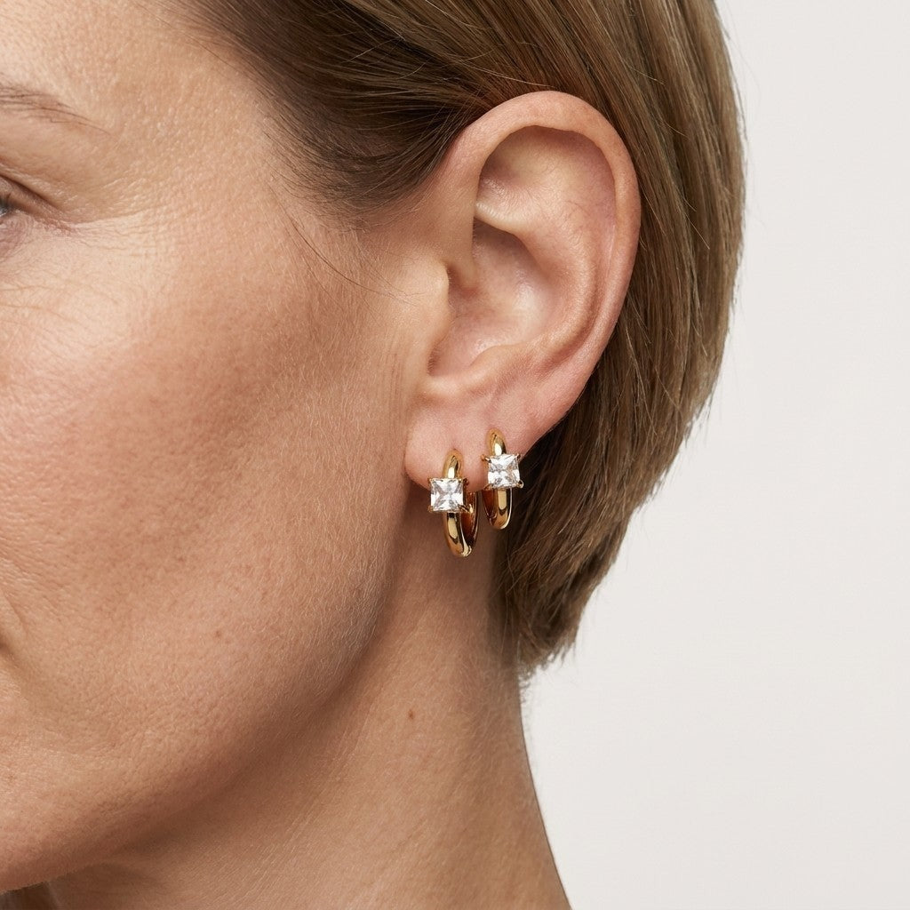 Aramat Jewels gold hoop earrings with square clear cubic zirconia. Small hoops with a modern design.