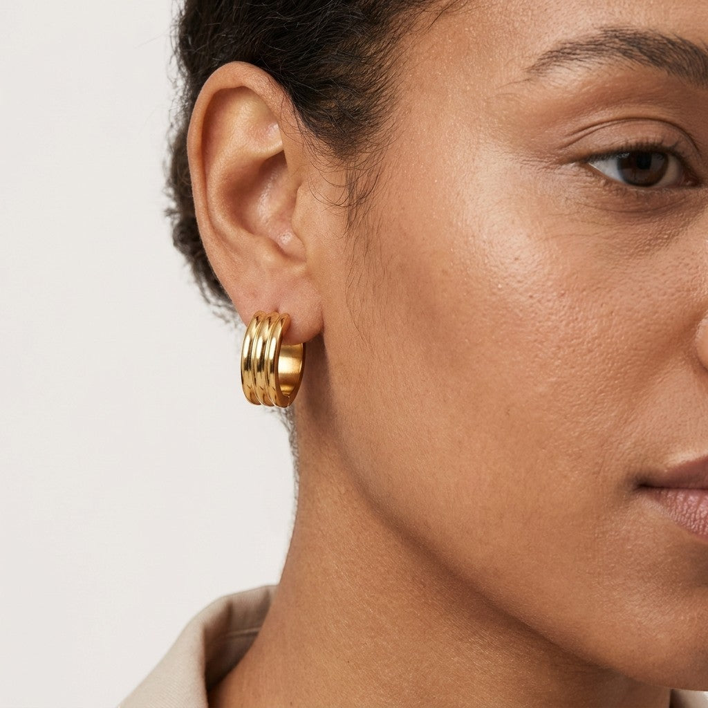 Aramat Jewels gold-tone stainless steel hoop earrings with three stacked bands, 13mm or 20mm diameter.