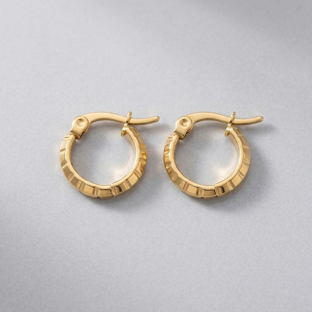 Aramat Jewels small gold hoop earrings with a subtle stripe pattern, 10mm diameter, made of stainless steel.
