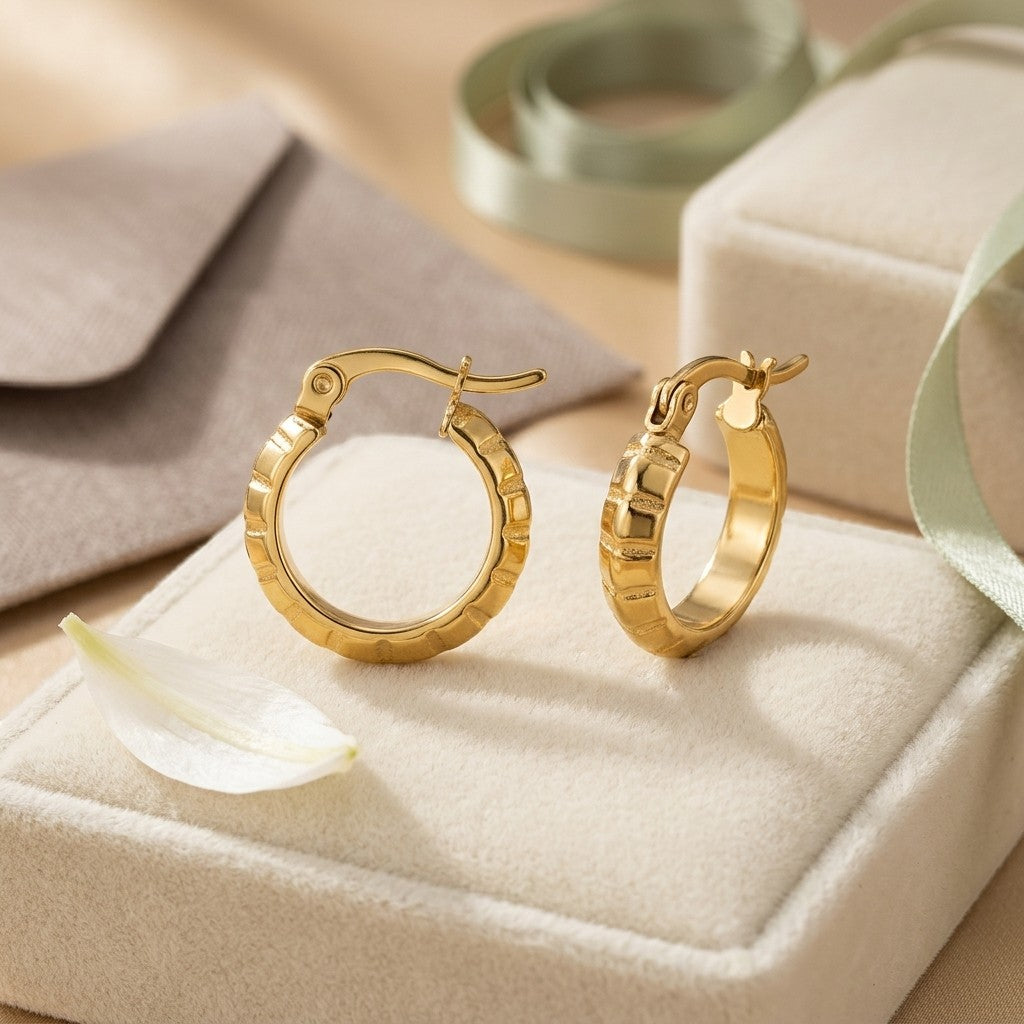 Aramat Jewels small gold hoop earrings with a subtle stripe pattern, 10mm diameter, made of stainless steel.
