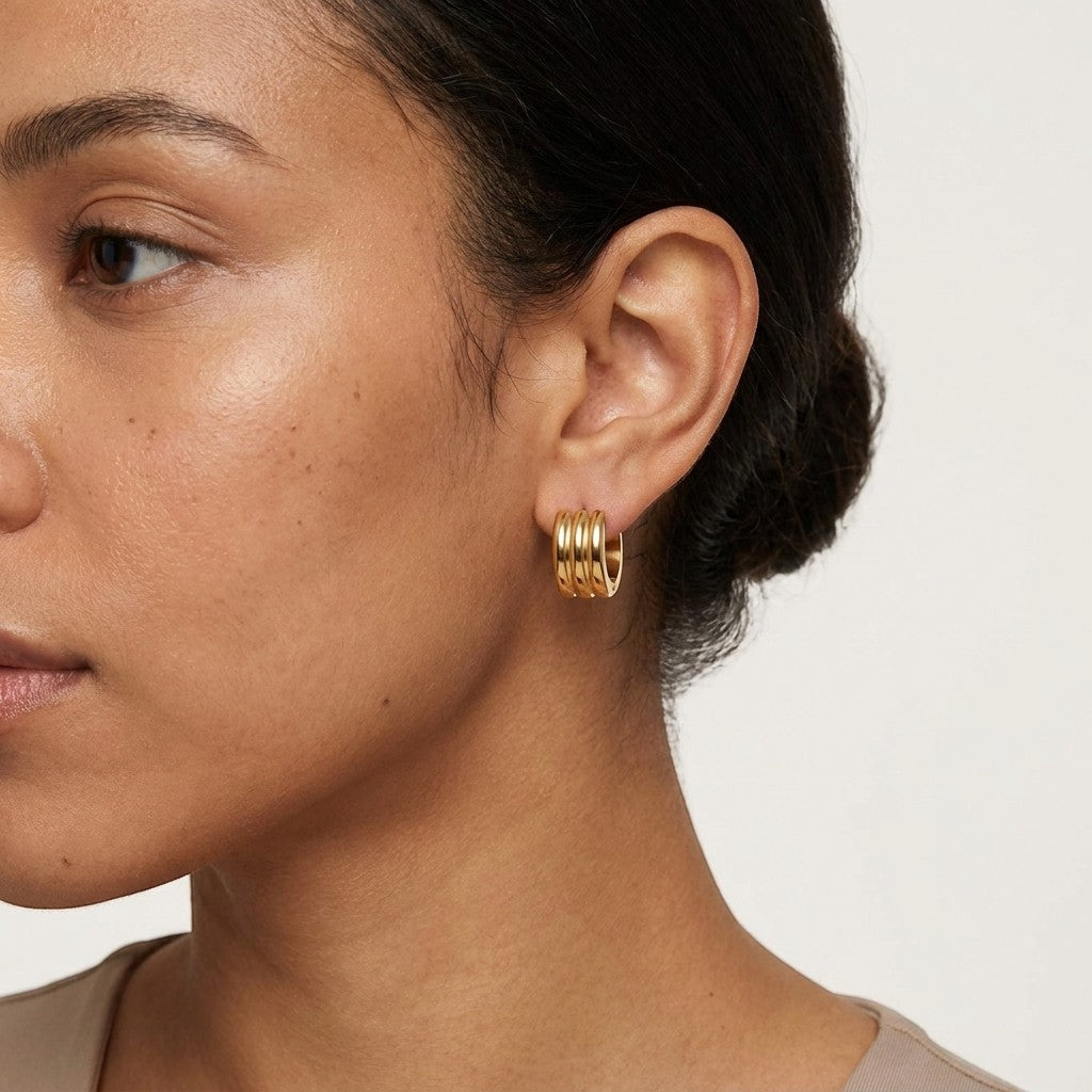 Aramat Jewels gold-tone stainless steel hoop earrings with three parallel stripes, 13mm or 20mm diameter.