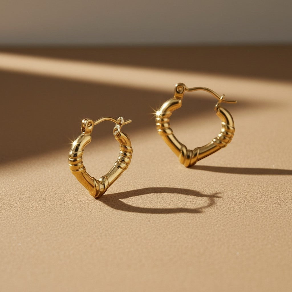 Aramat Jewels gold stainless steel hoop earrings with subtle stripe engraving, 22x20mm, featuring a hinge closure.