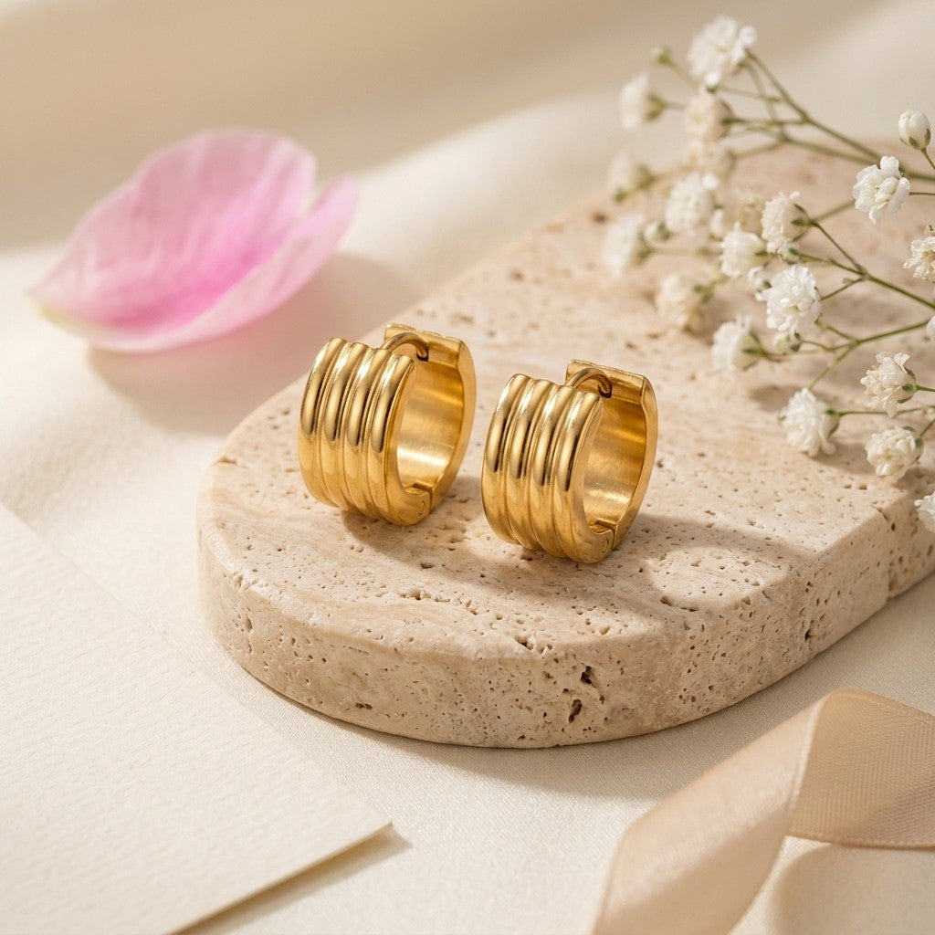 Aramat Jewels gold-tone stainless steel huggie hoop earrings with triple stripe detail, 13mm or 20mm diameter.