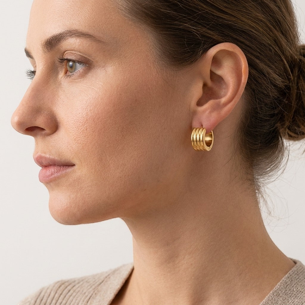 Aramat Jewels gold-tone stainless steel hoop earrings with triple stripe detail, 13mm or 20mm diameter.