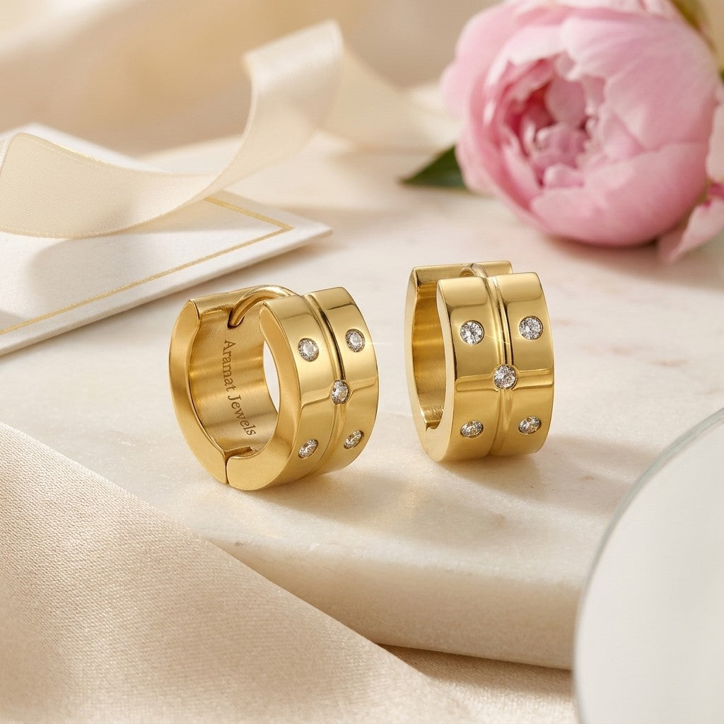 Aramat Jewels gold-colored stainless steel hoop earrings with 5 small cubic zirconia stones on each.