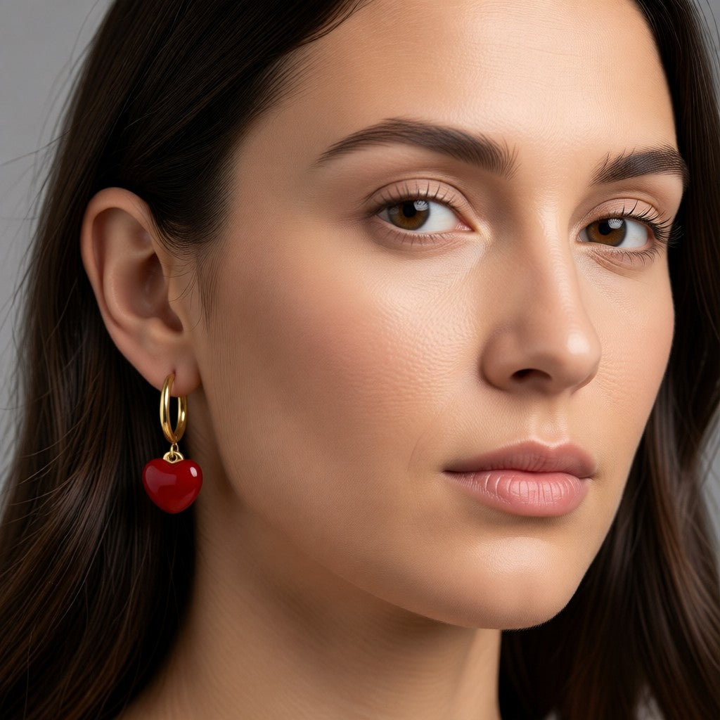 Aramat Jewels gold huggie hoop earrings with a red enamel heart charm, 14mm hoops with 12mm heart pendant.