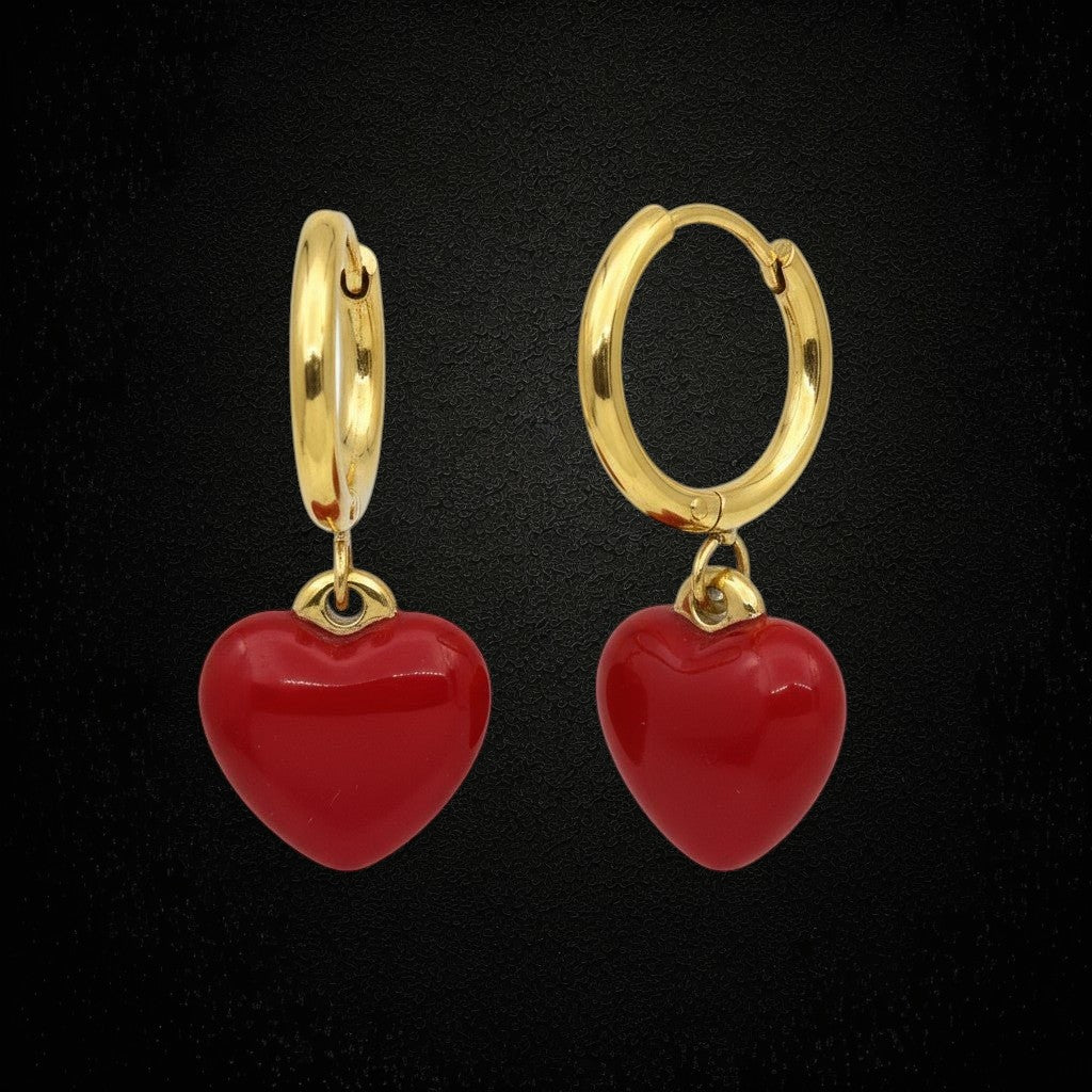 Aramat Jewels gold huggie hoop earrings with red enamel heart charms. Stainless steel with hinge closure.