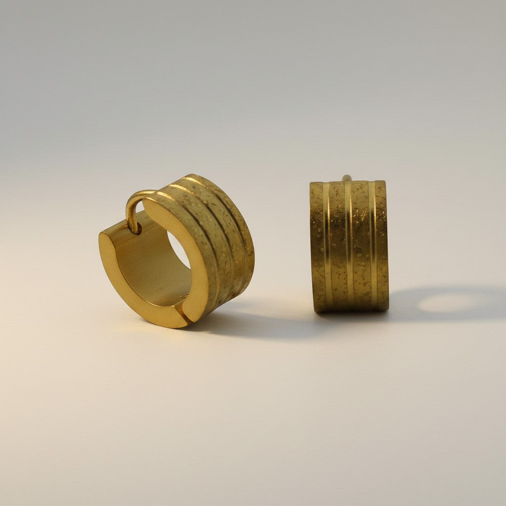 Aramat Jewels gold-tone stainless steel huggie hoop earrings with sandblasted stripes and a diamond-cut effect.