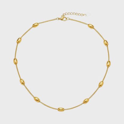Aramat Jewels gold-colored stainless steel necklace featuring delicate oval beads on a fine chain with a lobster clasp.