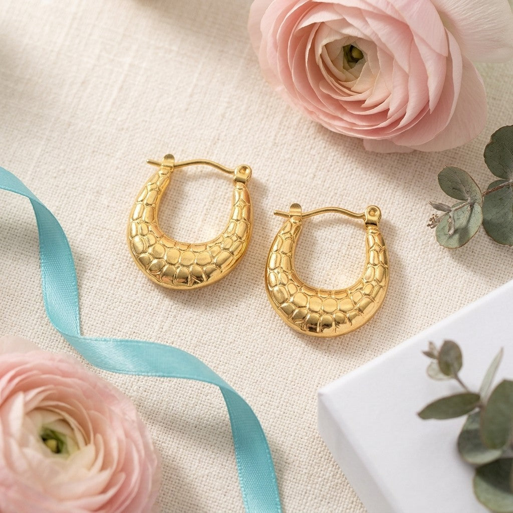 Aramat Jewels gold oval hoop earrings with textured pattern, 25x19mm, made of stainless steel.