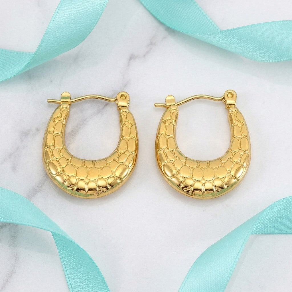 Aramat Jewels gold oval hoop earrings with a textured pattern, 25x19mm, made of stainless steel.
