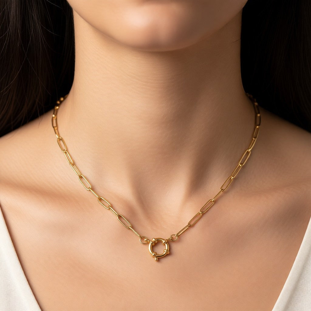 Aramat Jewels gold-tone stainless steel paperclip chain necklace with a circular clasp, worn by a model.