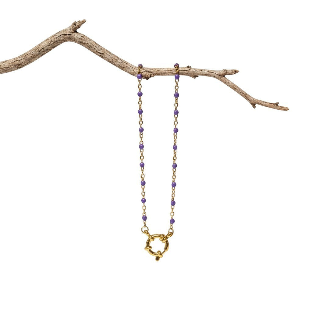 Aramat Jewels gold-tone stainless steel necklace with small purple enamel beads and a large clasp.