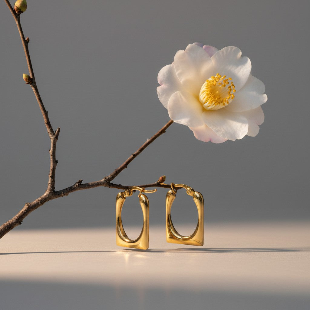 Aramat Jewels gold-tone stainless steel rectangular hoop earrings with a smooth finish and hinge closure.