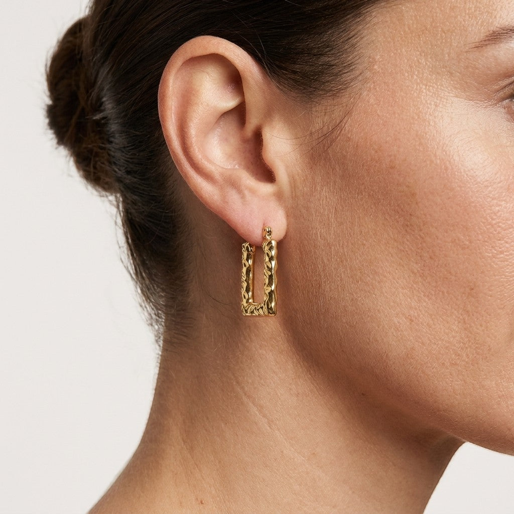 Aramat Jewels gold rectangular hoop earrings with a textured stripe pattern, 26x18mm, worn by a model.