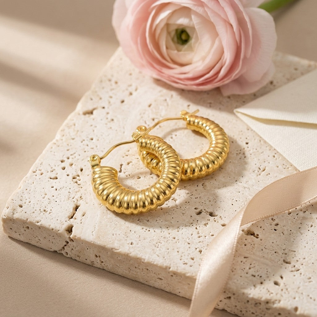 Aramat Jewels gold-coloured stainless steel hoop earrings with a ribbed texture, 20mm diameter.