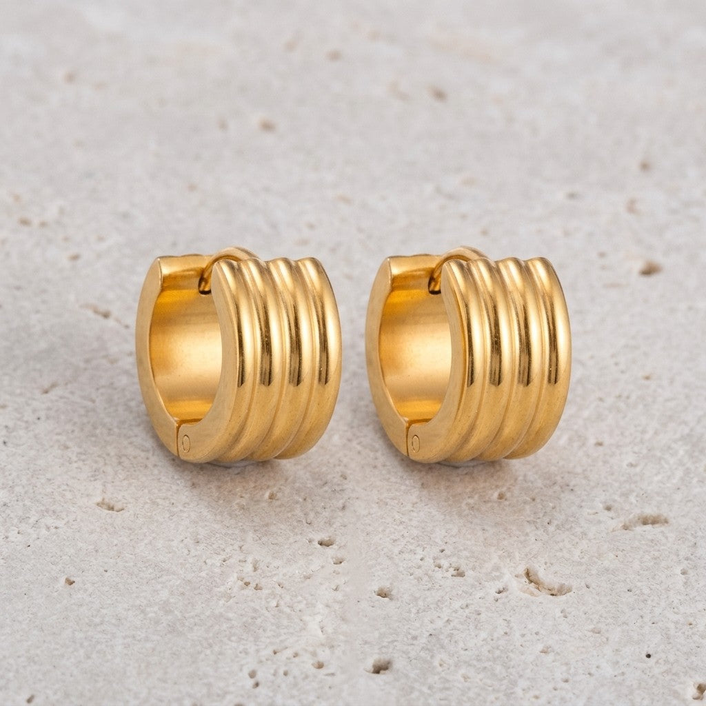 Aramat Jewels gold-tone stainless steel huggie hoop earrings with triple ribbed detail, 13mm or 20mm diameter.