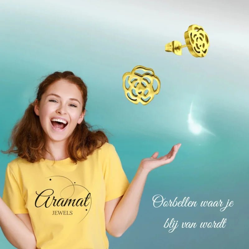 Aramat Jewels gold-colored stainless steel rose stud earrings with an open-cut design worn by a smiling woman.