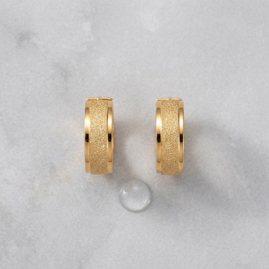 Aramat Jewels gold-tone stainless steel hoop earrings with sandblasted texture, 13mm or 20mm diameter.
