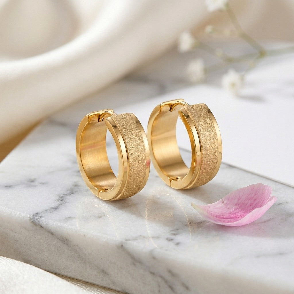 Aramat Jewels gold-tone stainless steel hoop earrings with sandblasted texture, 13mm or 20mm diameter.