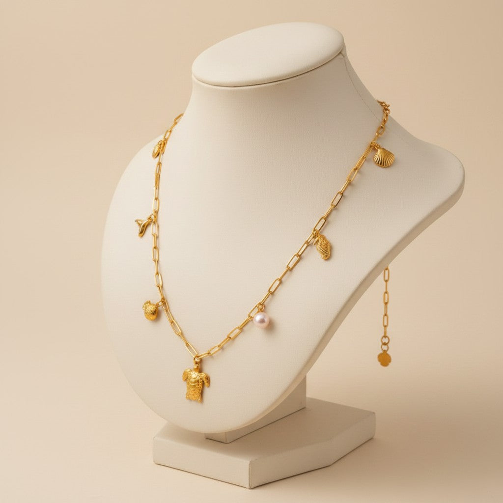 Aramat Jewels gold-tone stainless steel necklace with pearl and sea charms: turtle, fish, seahorse, and tail fin.