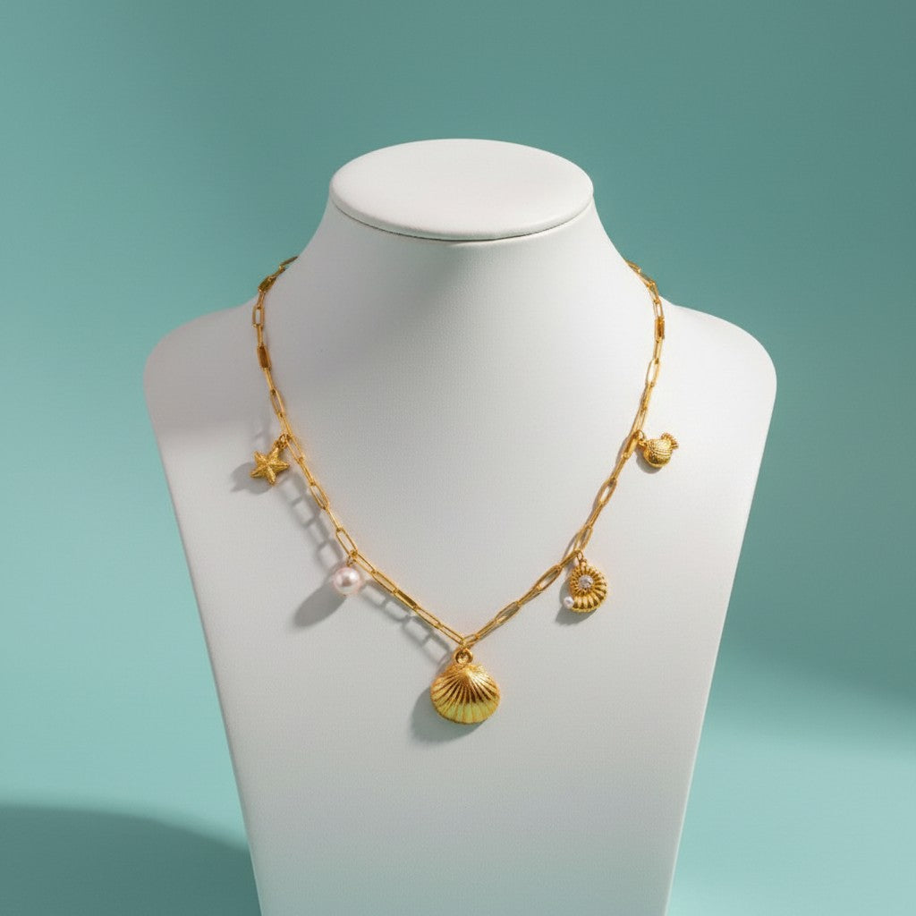 Aramat Jewels gold-tone link chain necklace with pearl and sea-themed charms: starfish, shell, snail, and turtle.