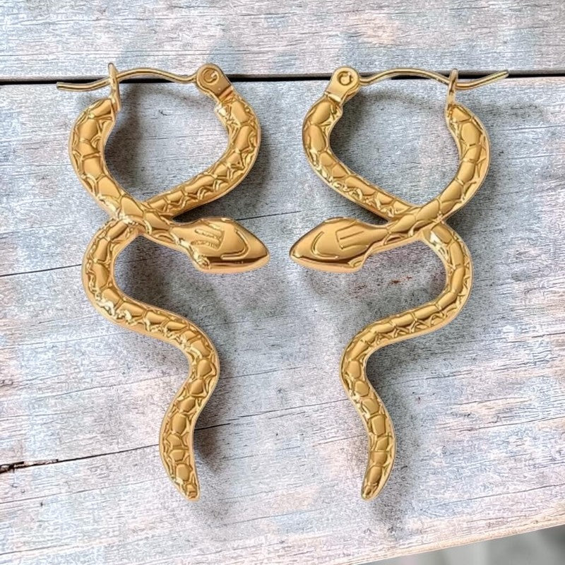 Aramat Jewels gold-tone stainless steel snake hoop earrings with textured scales, 42x17mm.
