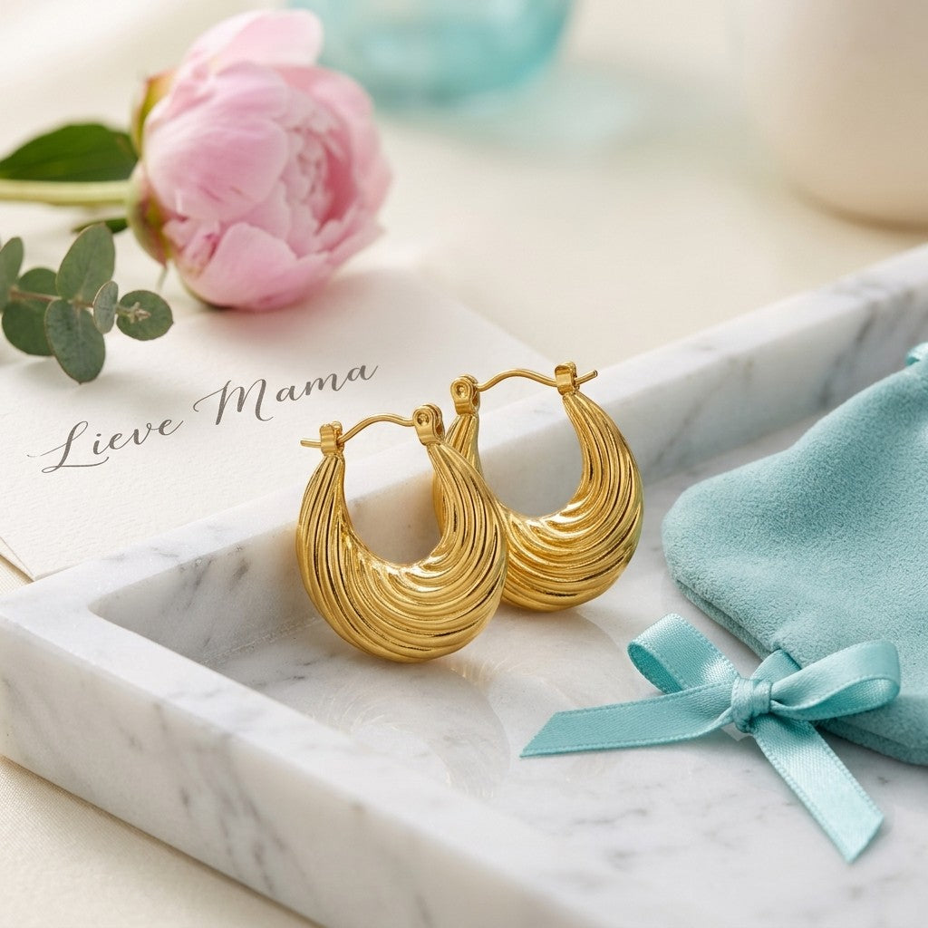 Aramat Jewels gold-colored stainless steel hoop earrings with a curved striped design, 20mm diameter.