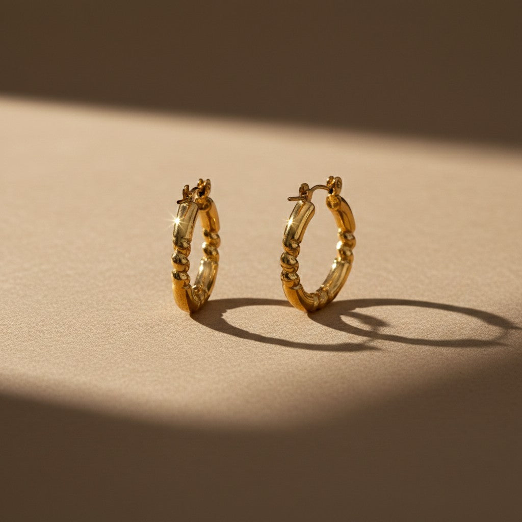 Aramat Jewels gold-coloured stainless steel hoop earrings with a striped engraving, 26x25mm, featuring a hinge closure.