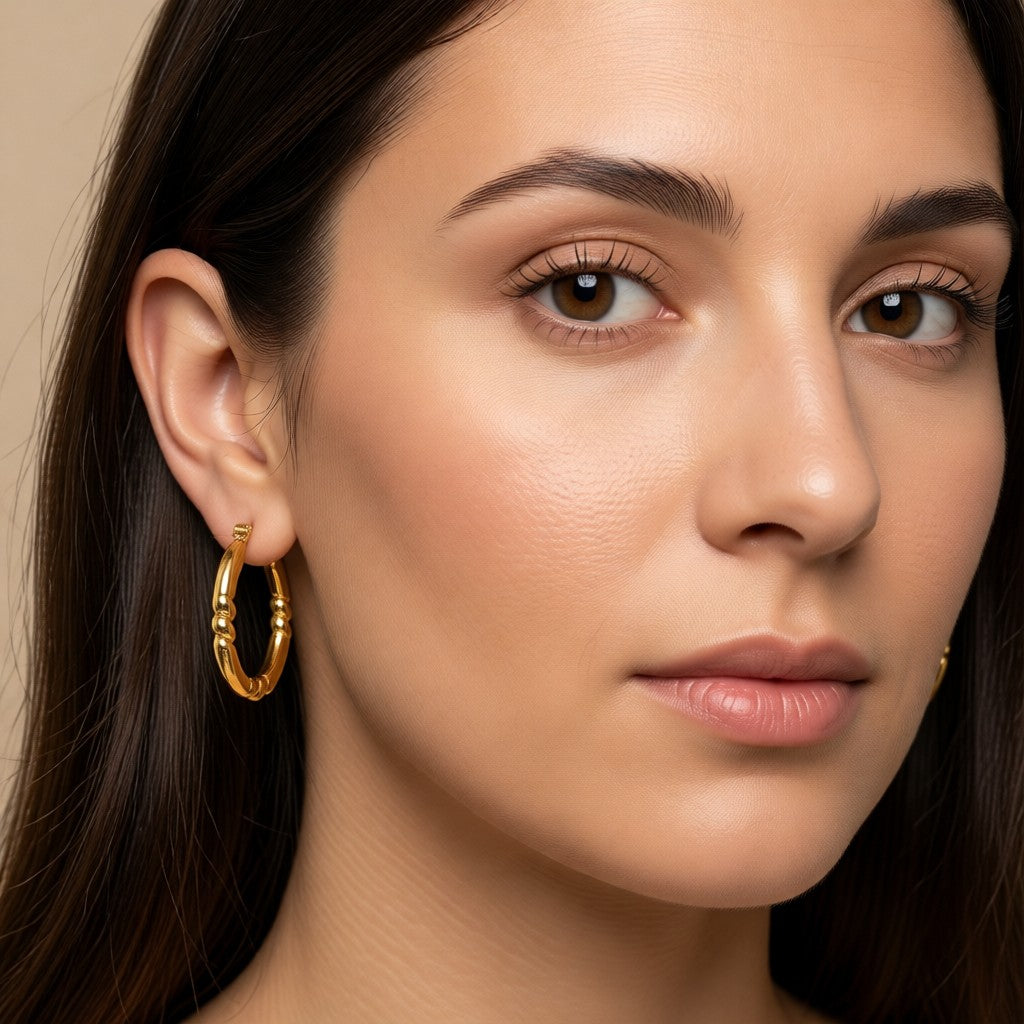 Aramat Jewels gold-coloured RVS hoop earrings with a striped engraving, 26x25mm, featuring a hinge closure.