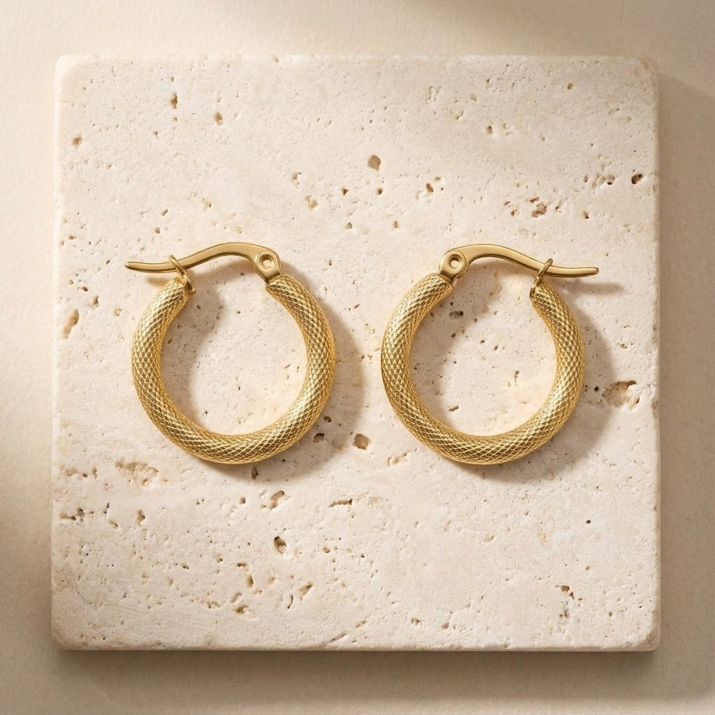 Aramat Jewels gold textured hoop earrings, 22mm diameter, made of stainless steel with a textured finish and hinge clasp.