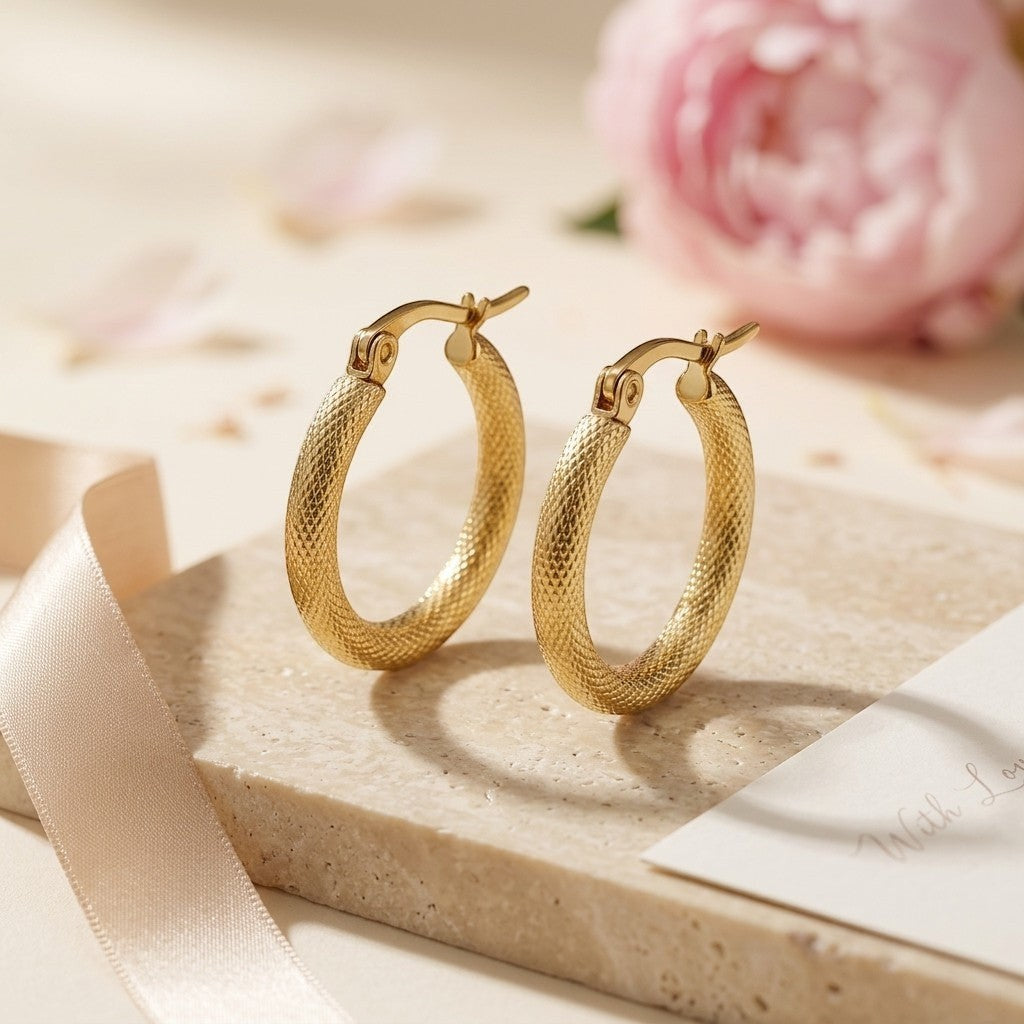Aramat Jewels gold textured hoop earrings, 22mm diameter, made of stainless steel with a hinge closure.
