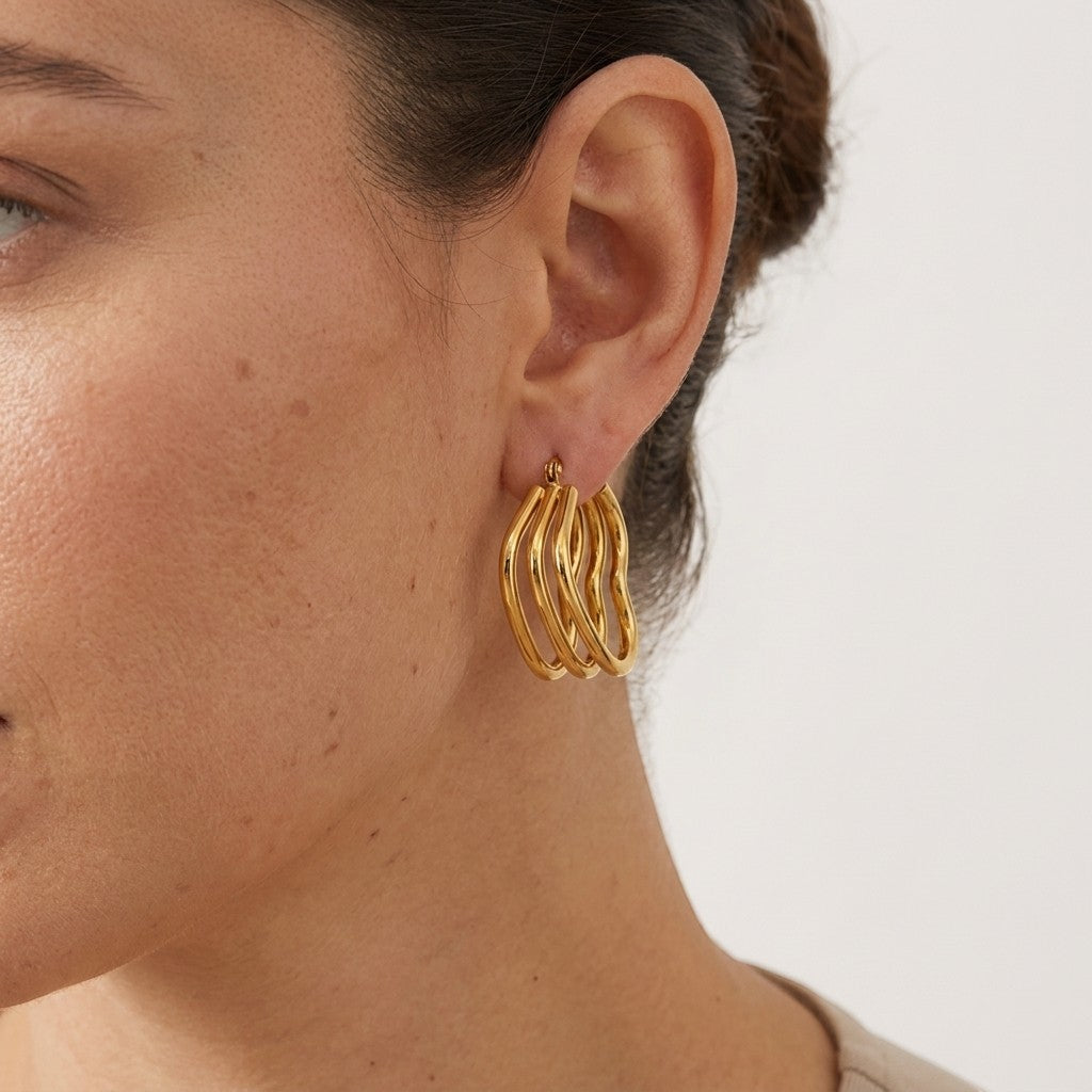 Aramat Jewels gold triple heart hoop earrings, 25mm, made of stainless steel with a hinge closure.