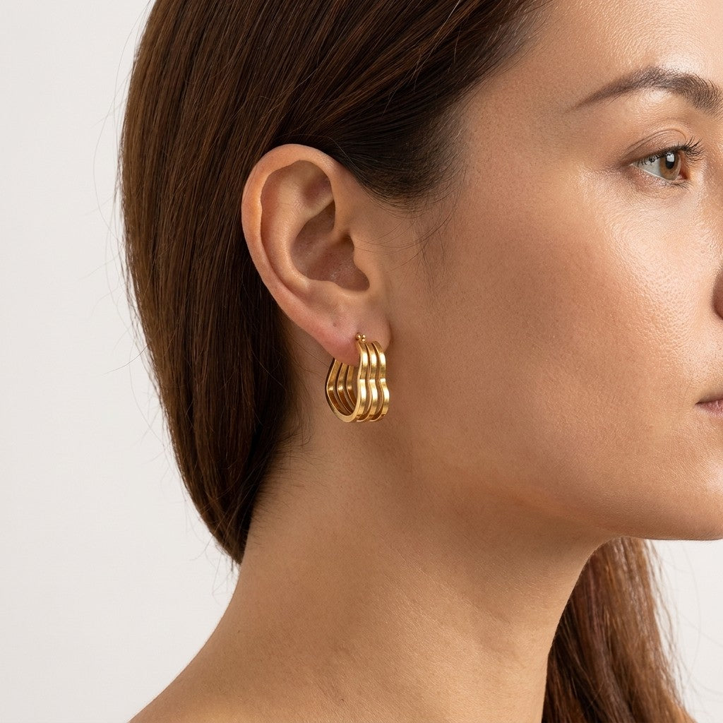 Aramat Jewels gold-tone triple heart hoop earrings, 25mm, made of stainless steel with a smooth finish.