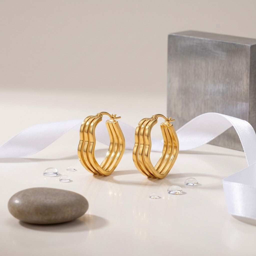 Aramat Jewels gold-colored triple heart hoop earrings, 25mm, made of stainless steel with a smooth finish.