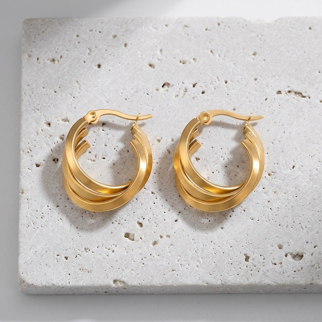 Aramat Jewels gold-coloured triple hoop earrings with a crossed design, 25x7mm, made of stainless steel.