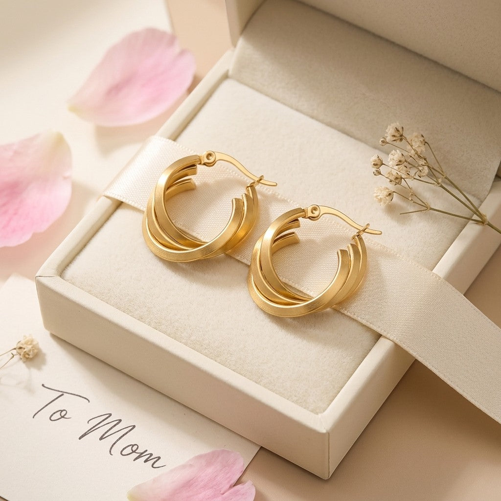 Aramat Jewels gold-coloured triple hoop earrings with a crossed design, 25x7mm, made of stainless steel.