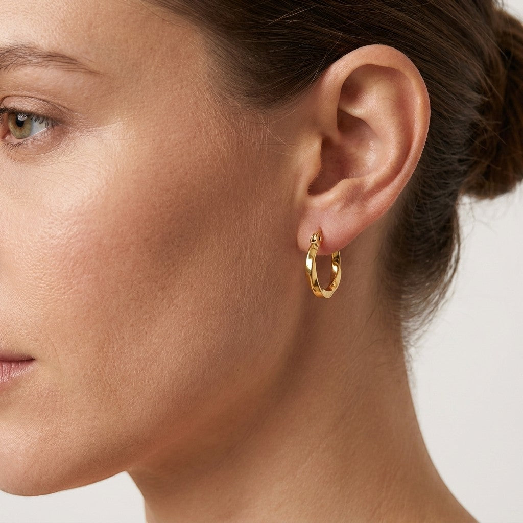 Aramat Jewels gold twisted hoop earrings, 10mm diameter, made of stainless steel with a hinge closure.