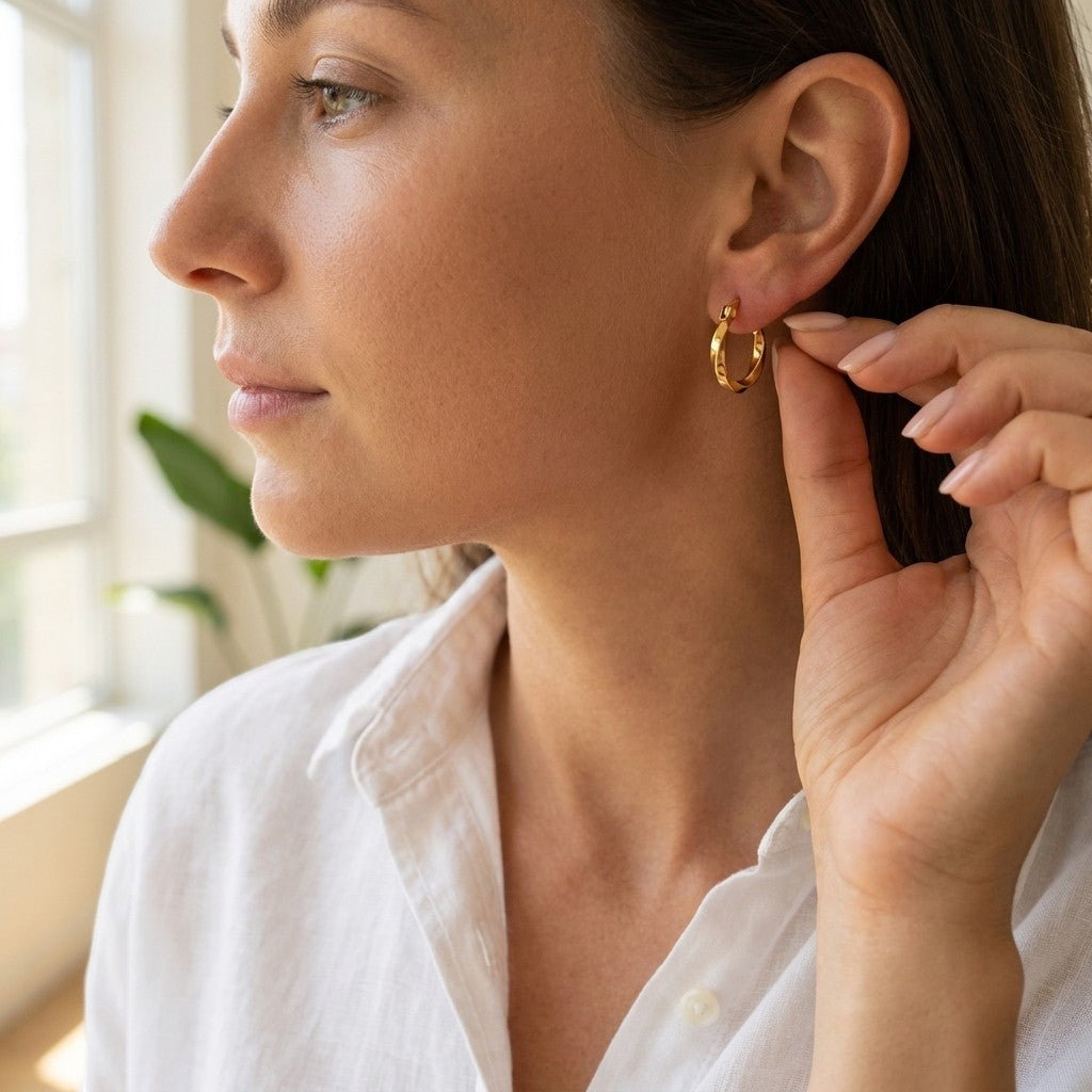 Aramat Jewels gold twisted hoop earrings, 10mm diameter, made of stainless steel with a hinge closure.