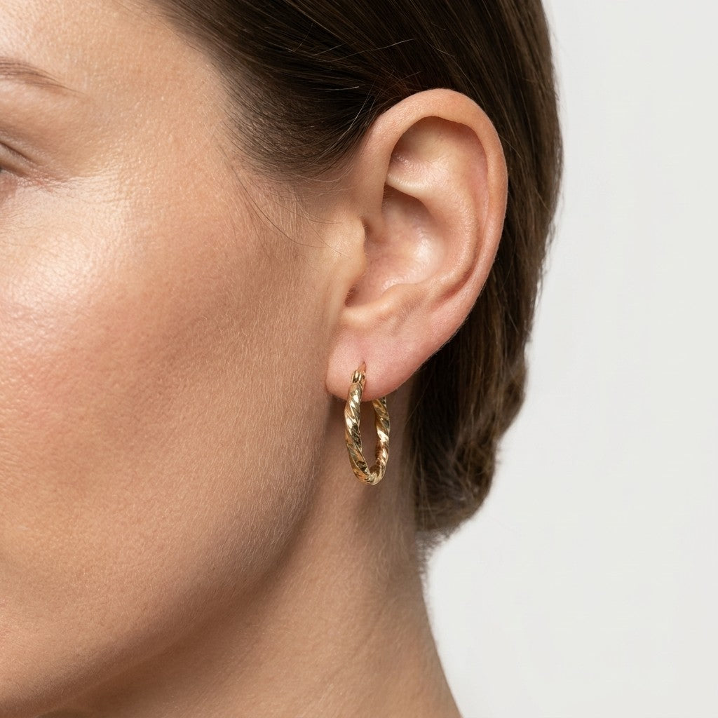 Aramat Jewels gold-tone stainless steel twisted hoop earrings, 20mm diameter, with a braided design and secure clasp.