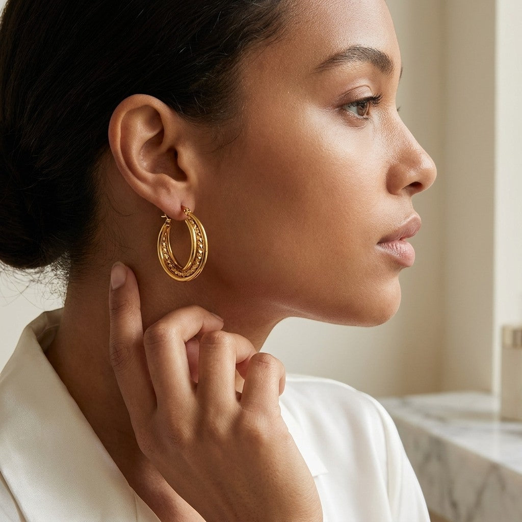 Aramat Jewels triple hoop earrings in gold-tone stainless steel with a twisted design, 25mm diameter.