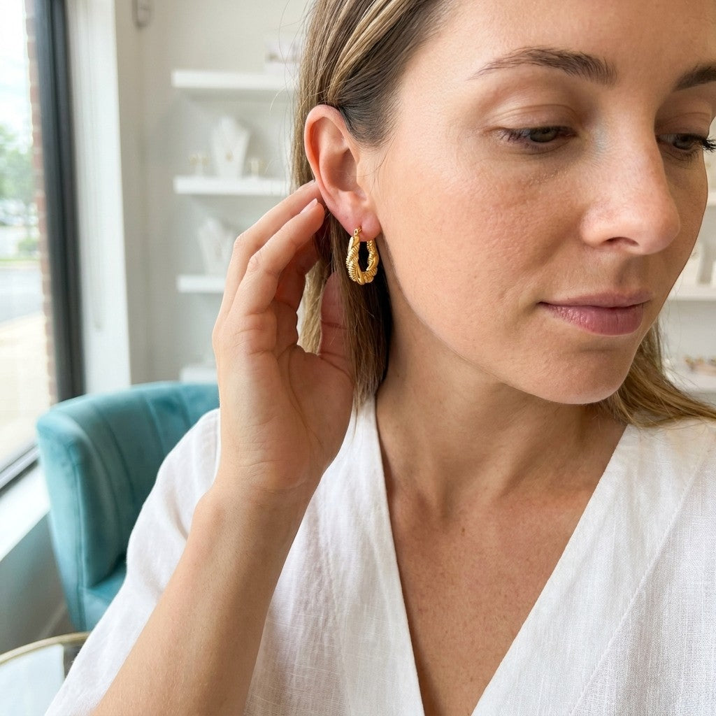 Aramat Jewels gold-tone twisted rectangular hoop earrings, 26x20mm, stainless steel, worn by a woman.