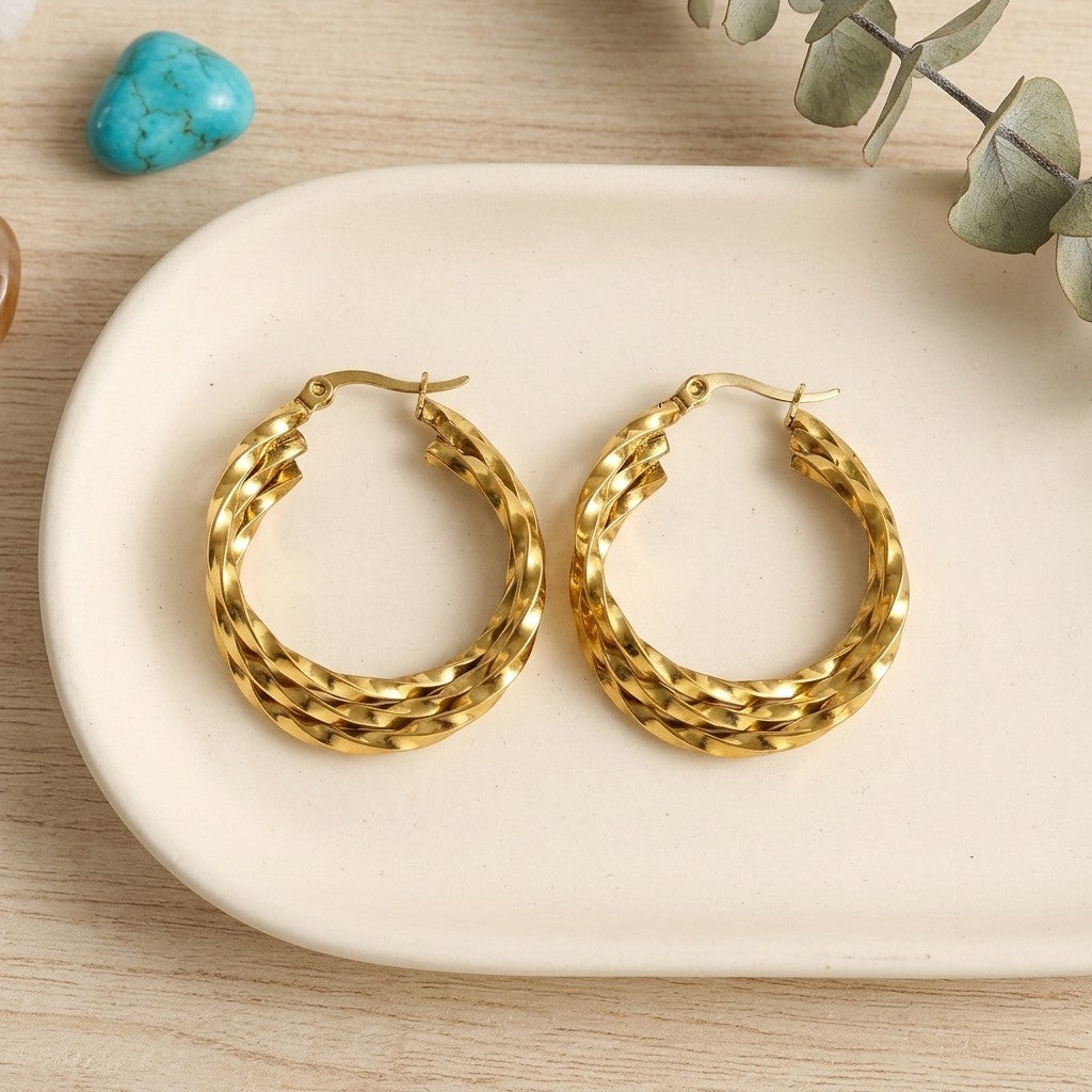 Aramat Jewels gold-tone stainless steel triple twisted hoop earrings, 25mm or 30mm diameter, statement jewelry.