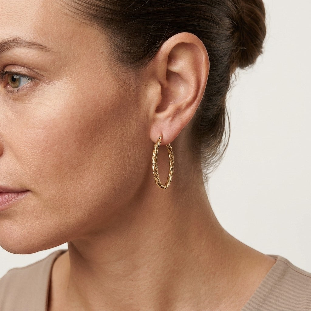 Aramat Jewels gold-tone stainless steel hoop earrings with a twisted, two-strand design, 30mm diameter.