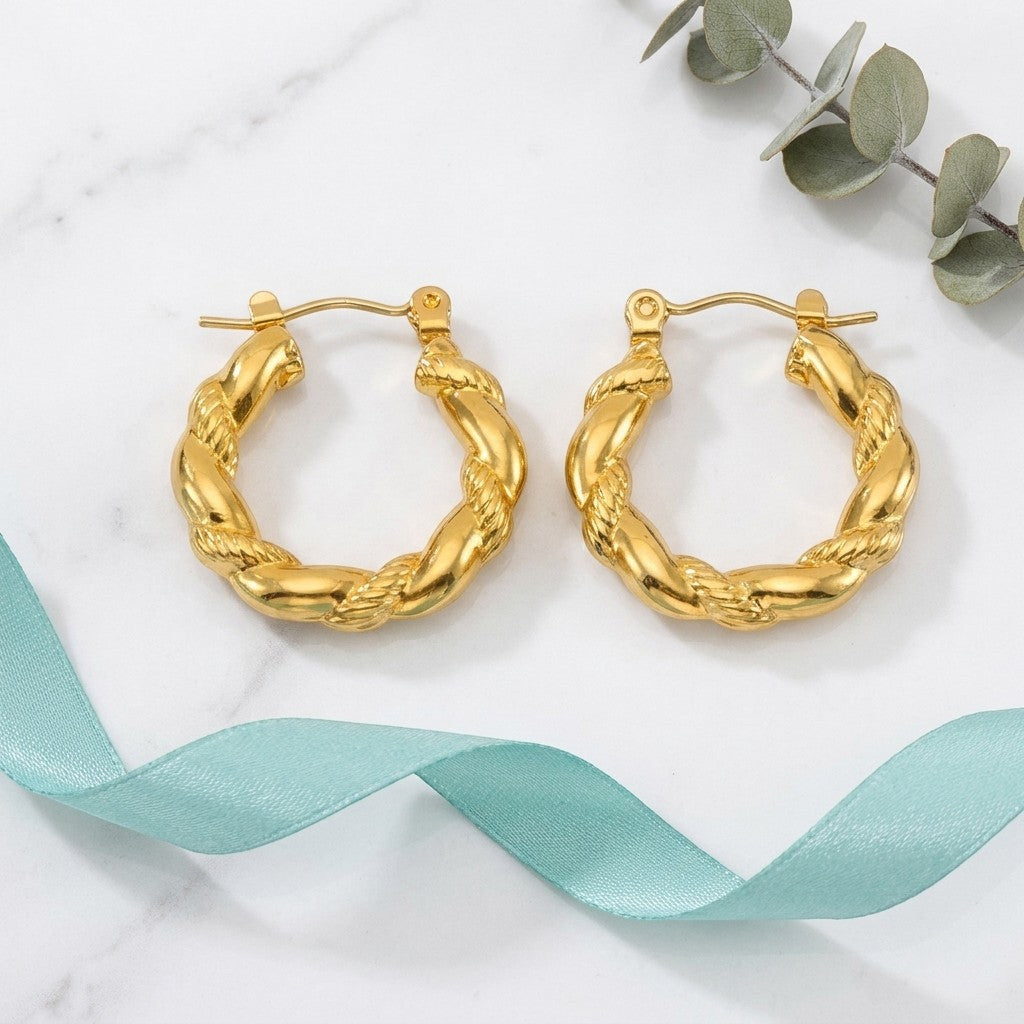 Aramat Jewels gold-colored stainless steel twisted hoop earrings, 22mm diameter, with a rope-like texture.