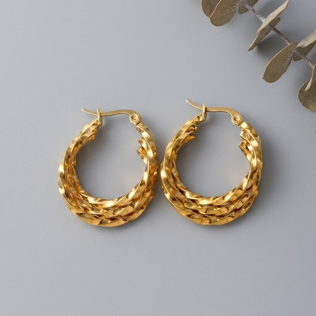 Aramat Jewels gold-tone stainless steel triple twisted hoop earrings, 25x7mm, with a hinged closure.