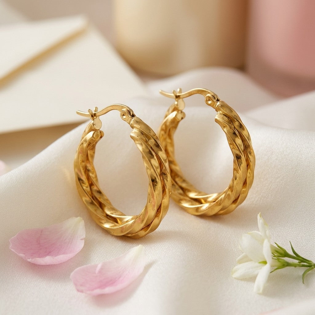 Aramat Jewels gold-tone twisted triple hoop earrings, 25x7mm, made of stainless steel with a hinge closure.