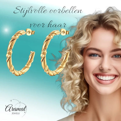 Aramat Jewels gold-tone stainless steel hoop earrings with a twisted rope pattern, worn by a smiling blonde woman.